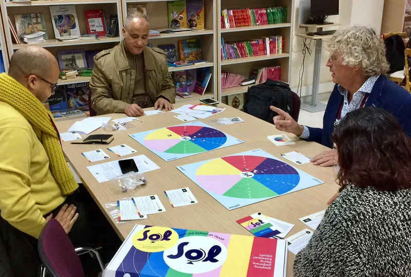 Kleine groep speelt het SOL-bordspel in een internationale setting